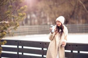 Smiling young girl skating on ice rink outdoors photo