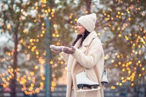 Smiling young girl skating on ice rink outdoors photo