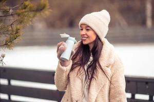 Smiling young girl skating on ice rink outdoors photo