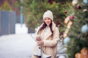 Smiling young girl skating on ice rink outdoors photo