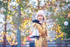 Cute little kid girl is going skate outdoors. photo