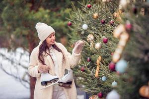 Smiling young girl skating on ice rink outdoors photo