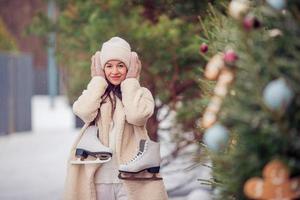 Smiling young girl skating on ice rink outdoors photo