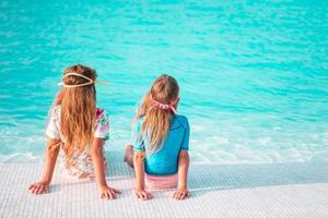 adorables niñas jugando en la piscina al aire libre de vacaciones foto