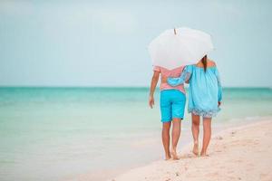 Young family of two on white beach have a lot of fun photo