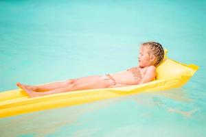 Cute little girl enjoy vacation in the swimming pool photo