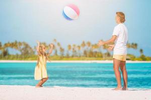 Happy family on the beach with ball photo