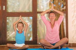 madre e hija haciendo ejercicio de yoga al aire libre foto