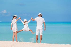 familia feliz de tres divirtiéndose juntos en la playa foto