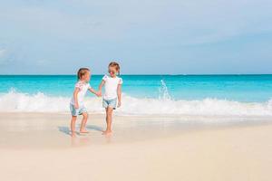 Adorable little girls have a lot of fun on the beach. photo