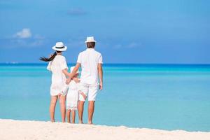 Happy family of three having fun together on the beach photo