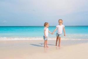 Adorable little girls have a lot of fun on the beach. photo