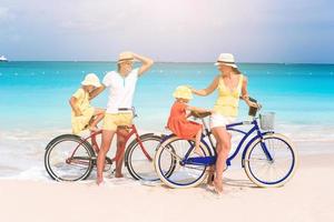 familia con una bicicleta en la playa tropical foto