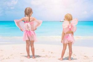 Adorable little girls have a lot of fun on the beach. photo