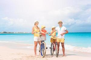 familia con una bicicleta en la playa tropical foto