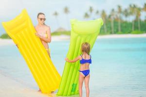 Beautiful mother and daughter at Caribbean beach enjoying summer vacation. photo