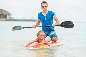 familia de papá e hijos en tablas de surf durante las vacaciones de verano foto