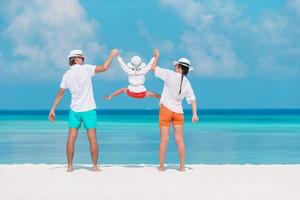 Happy family of three having fun together on the beach photo