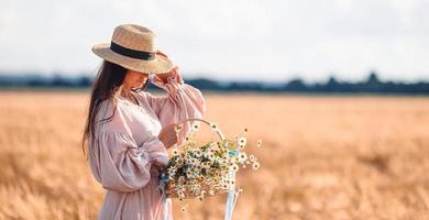 Beautiful girl in wheat field with ripe wheat in hands photo