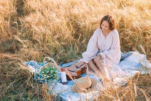 Beautiful girl in wheat field with ripe wheat in hands photo