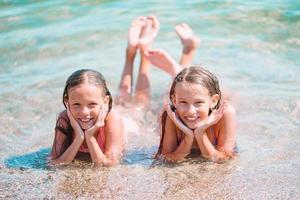 Adorable little girls having fun on the beach photo