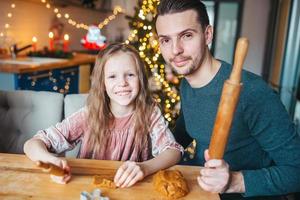 familia horneando galletas de jengibre en vacaciones de Navidad foto