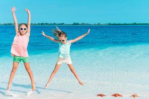 Adorable little girls have a lot of fun on the beach. photo