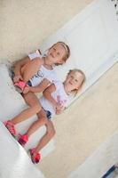 Little cute sisters sitting near old house in Greek village of Emporio, Santorini photo