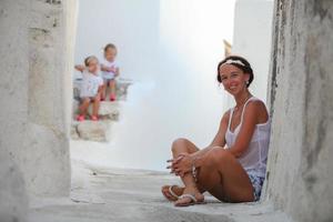 Happy mother background her adorable daughters in a Greek village on the Cyclades Islands photo