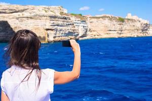 Girl taking pictures on a phone in Bonifacio, Corsica, France photo