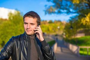 Young man with talking by phone outoors photo