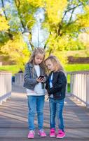 Adorable little girls at warm autumn day outdoors photo