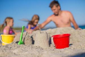 Father and adorable little daughter playing with beach toys photo