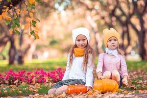 niñas adorables con calabaza al aire libre en un cálido día de otoño. foto