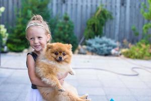 niña rubia con su perro mascota al aire libre en el parque foto