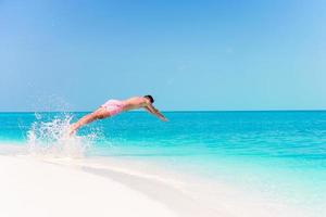 Young man plunging into the turquoise sea photo