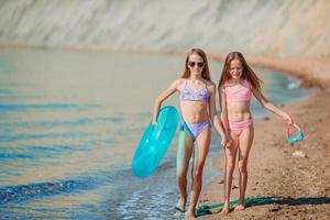 Little happy funny girls have a lot of fun at beach playing together photo