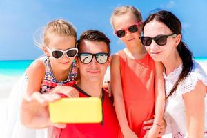 Young beautiful family taking selfie portrait on the beach photo