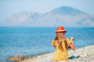 Cute little girl at beach during summer vacation photo