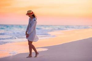 Young beautiful woman in sunset background of ocean photo