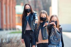 Family wearing a mask on a background of a modern building, photo