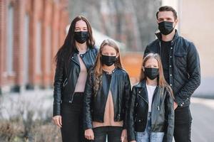 Family wearing a mask on a background of a modern building, photo
