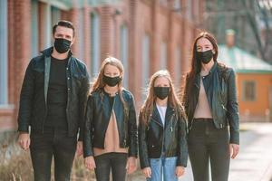 Family wearing a mask on a background of a modern building, photo
