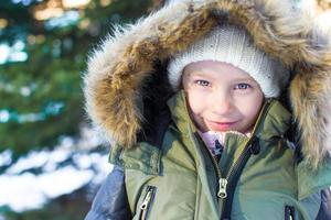 Portrait of little happy girl in snow sunny winter day photo