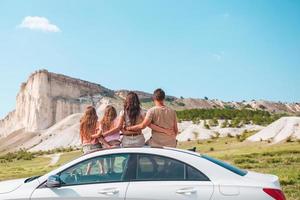 familia feliz de cuatro personas caminando en las montañas foto