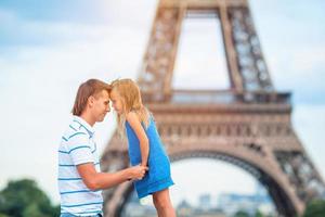 niña linda y su padre en parís cerca de la torre eiffel durante las vacaciones de verano en francés foto