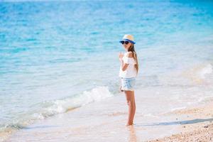 Adorable little girl have fun at tropical beach during vacation photo