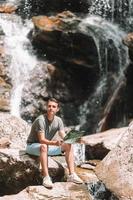 Man enjoying view of waterfall in gungle photo