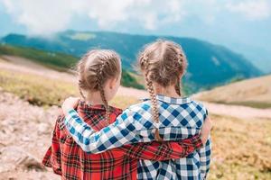 Beautiful happy little girls in mountains in the background of fog photo