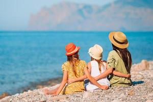 Adorable little girls and young mother on tropical white beach photo